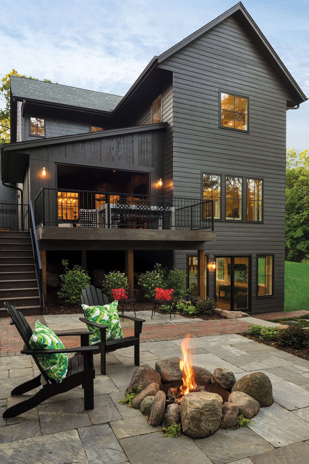 A stone fire pit accents a brick patio.