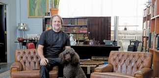 Peter Dyste’s Antique & Real Estate Sales Tips Peter Dyste sitting in a living room on a couch with his dog.