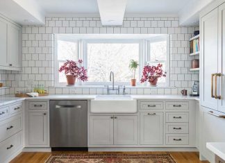 2017 ASID Designer Kitchen Tour: Kate Roos Design, LLC A kitchen designed by Kate Roos of Kate Roos Design, LLC features all white cabinetry and countertops with a white subway tiled backsplash. In the large window over the sink sit two pink flowers.