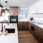 Shelter Architecture A kitchen designed by Shelter Architecture on the 2017 ASID Designer Kitchen Tour. Dark wood cabinetry is accented with white countertops and black appliances.