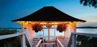 The top level of the Abbott Boathouse shows a cozy gazebo with hanging potted plants that looks out onto Lake Minnetonka.