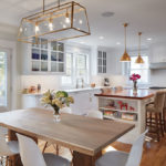 A Linden Hills Remodel Balances Old with New A remodeled kitchen gives a modern feel and features hardwood flooring, white cabinetry, and a wrought-iron chandelier of the dining table.
