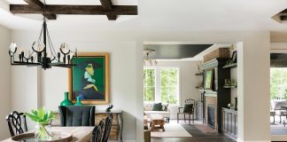 Virtual Luxury Home Tour A great room with a dining room table in the foreground and living room in the background. All throughout is random-plank, cerused white oak flooring and reclaimed timbers.