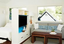 A small living and bedroom separated by shelving.