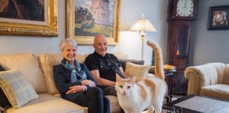 2017 Luxury Loft & Condo Tour: Abiitan Mill City cat standing on coffee table in front of man and woman sitting on fabric couch