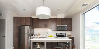 2017 Luxury Loft & Condo Tour: Revel modern kitchen with brown cabinets and center island with backless stools