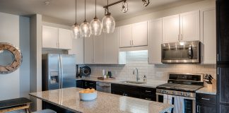 2017 Luxury Loft & Condo Tour: Onyx Edina kitchen with modern appliances and stools at a granite kitchen island