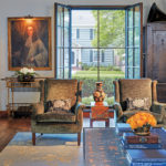 Inside Charlie Simmons and Sandy LaMendola’s Home A living room featuring a pair of chairs, silk-wool rug, gold-painted bamboo bar cart, and painting.