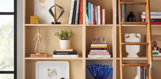 Stylish Book Shelves A home library stocked with books, artwork and a ladder resting on the shelves.