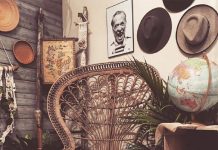 Rustic Charm at Lovegood and Co. Empty brown woven chair surrounded by plant and hats