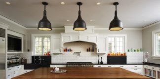 Christopher Strom Transforms Lake of the Isles Tudor White kitchen with black chairs and brown table