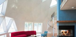 Luxury Super Bowl Rentals A great room with geometric-patterned windows, fireplace, large red sofa and spiral staircase.
