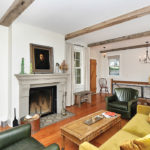 A West End Facelift by Studio Hittle Vintage treasures capture the feel of a mid-19th century home. Both the floor and the mantel are made from recycled materials in a living room designed by Studio Hittle.