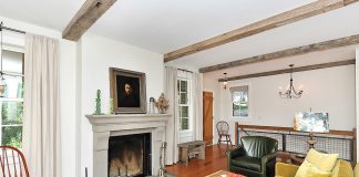 A West End Facelift by Studio Hittle Vintage treasures capture the feel of a mid-19th century home. Both the floor and the mantel are made from recycled materials in a living room designed by Studio Hittle.