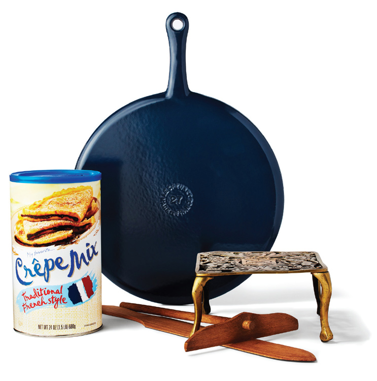 A crepe pan with crepe mix next to it.
