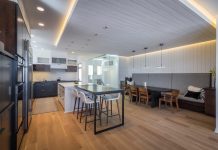 2018 Luxury Remodeling Tour: Revolution Design Build Photo of a modern kitchen and living space with wood floors remodeled by Revolution Design Build.