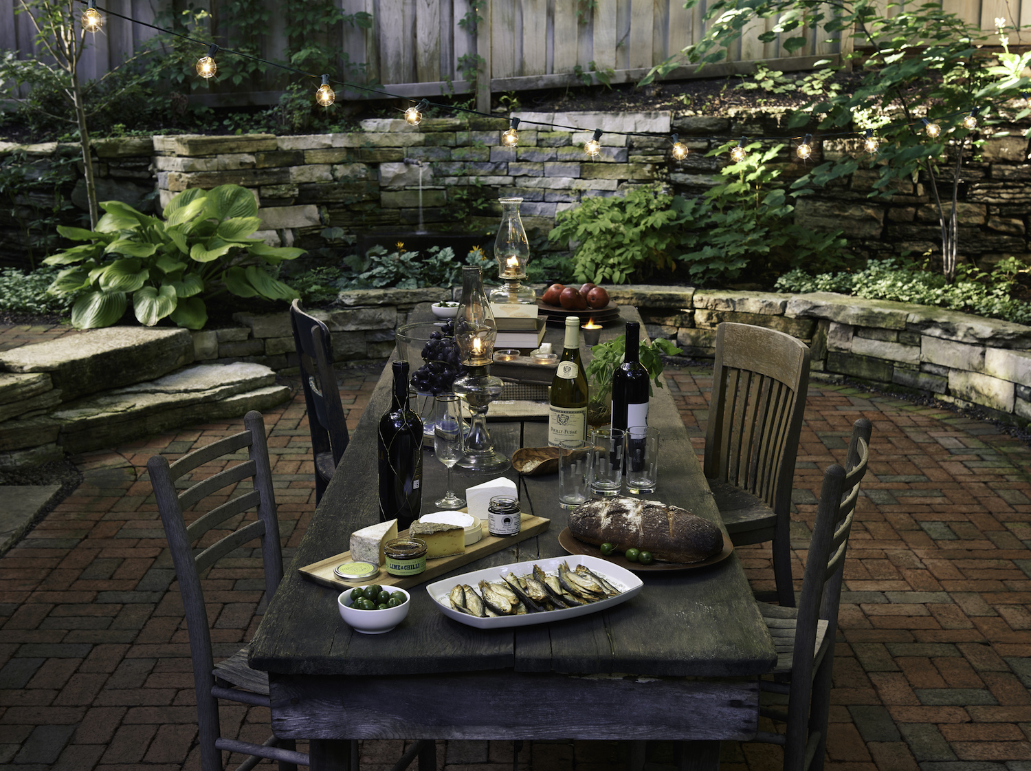 Dry-stack stone wall and old wood dining table in Minneapolis garden