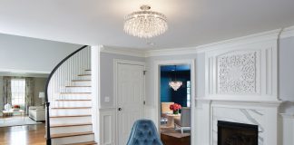 Clean white panels and a glossy dark wood floor provide the perfect backdrop for this elegant, blue-accented space designed by Martha O’Hara Interiors.