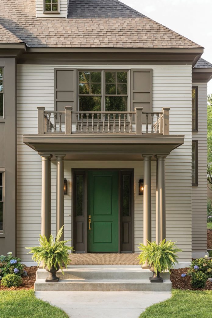 The entry of a home on Midwest Home's 2018 Luxury Home Tour that features a small deck overhanging a green door.