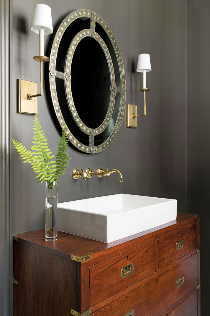 An antique, English campaign chest used as the vanity in the main-level bathroom. Part of Midwest Home's 2018 Luxury Home Tour.