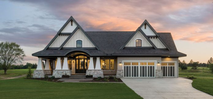 The front exterior of a home on Midwest Home's 2018 Luxury Home Tour that shows steepled features, pillars, and driveway.