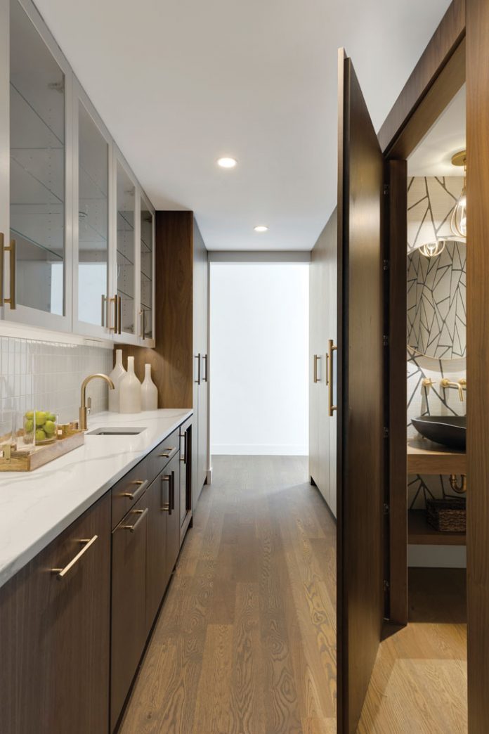 The pantry in this home on Midwest Home's 2018 Luxury Home Tour opens to a secret powder room.
