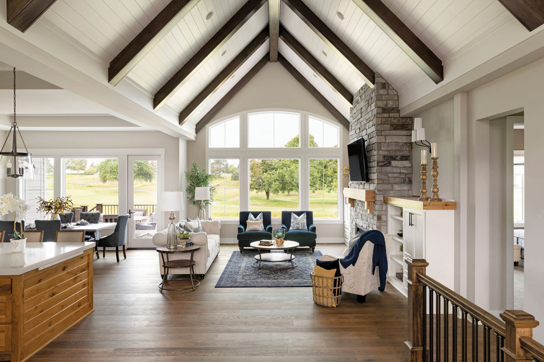 Inside, views of the hills can be enjoyed from the spacious great room, which showcases generous windows, a natural stone fireplace, and custom built-ins. Part of Midwest Home's Luxury Home tour 2018.