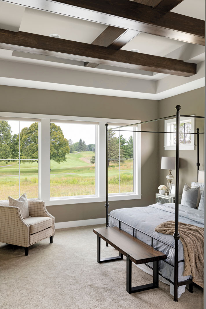 Taking design cues from the rest of the home, the master bedroom features a ceiling with floating dark wood beams. Part of Midwest Home's 2018 Luxury Home Tour.