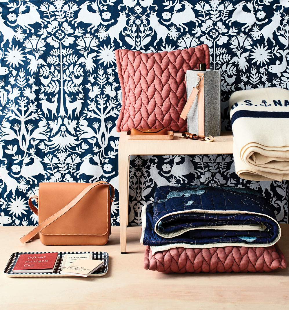 A collection of items in the Holiday Gift Guide that include a bag, books, pillows, and more.