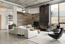 Room with an Obstructed View A reclaimed barn wood wall and floor-to-ceiling blackened steel fireplace add texture to the living room’s interiors while blending seamlessly with the views of surrounding mill buildings.