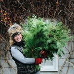 A portrait of Christine Hoffman, founder of Twin Cities Flower Exchange, holding green plants.