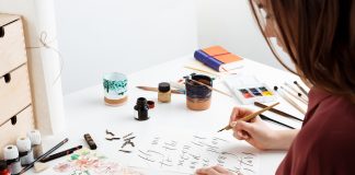 Girl writing calligraphy on postcards.