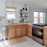 Small Space Renovation Provides Big Results Image of a white kitchen with light wood