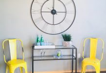 Home Stylist Answers Questions Via Facebook Live Two yellow, metal chairs with a glass table between them and decorations on the table and wall