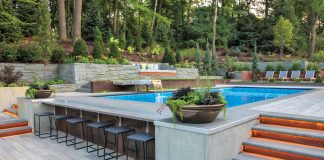 A Saltwater Oasis Lighted stairs lead down to the swim-up bar, dining table, and grill area, all of which overlook the surrounding wetlands.