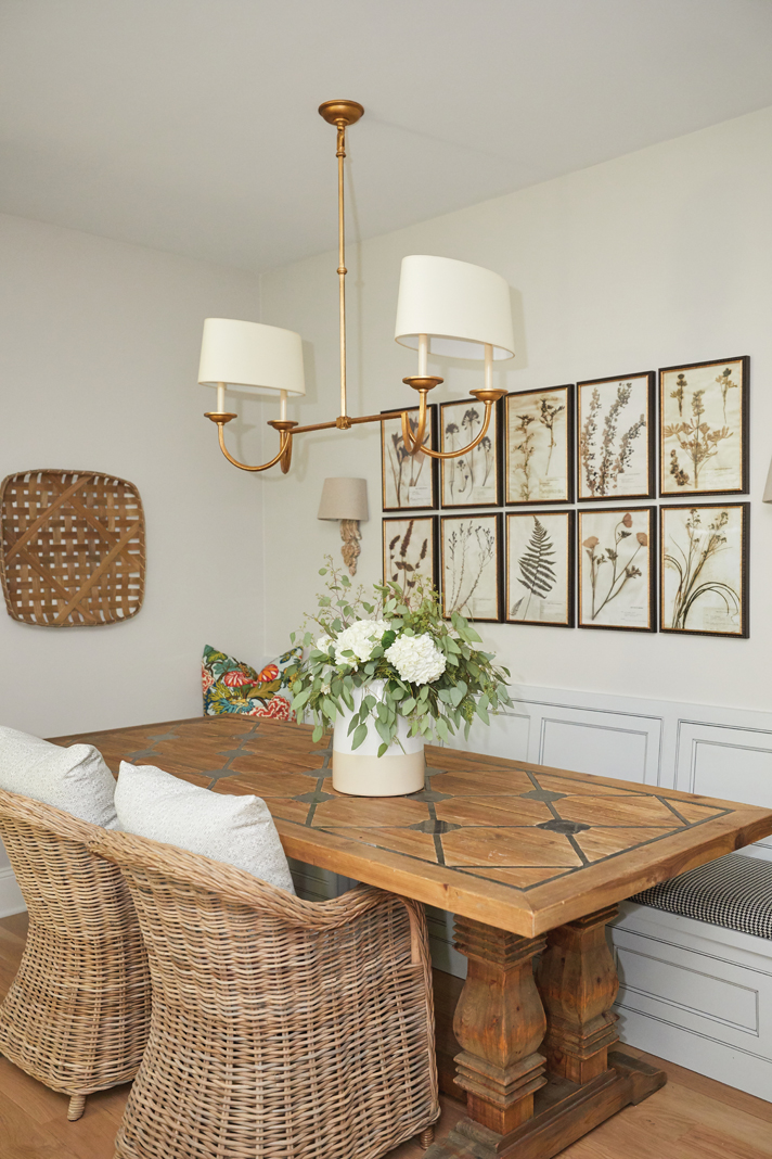 A framed set of botanical prints add a lovely design element to the nearby breakfast nook.