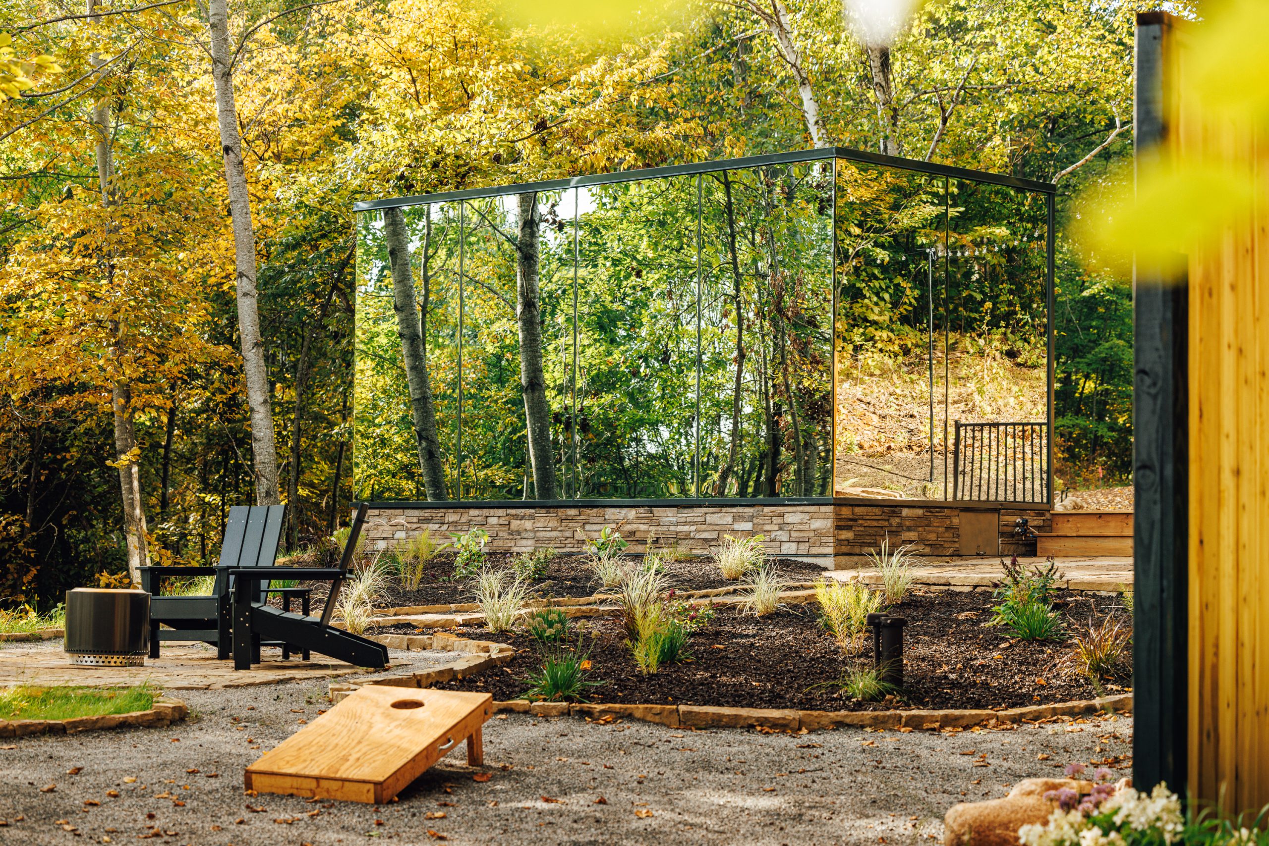 Mirror cabin in Crosby, Minnesota, reflects the surrounding forest during the daytime.