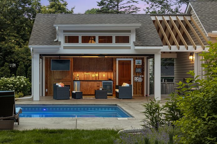 Pool and pool house with warm lighting
