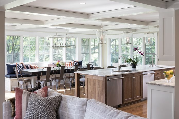 large windows light up a white open kitchen island and living room