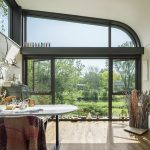 5 Home Offices That Inspire Productivity An art studio inside a home with large windows that look out to the creek.