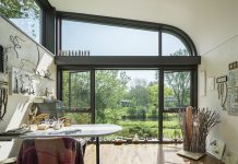 5 Home Offices That Inspire Productivity An art studio inside a home with large windows that look out to the creek.