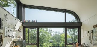 5 Home Offices That Inspire Productivity An art studio inside a home with large windows that look out to the creek.