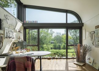 5 Home Offices That Inspire Productivity An art studio inside a home with large windows that look out to the creek.