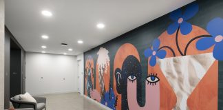 How Curators Bring Artistic Value to Commercial Design Projects An apartment building hallway featuring a mural with graphic shapes and whimsical design with bold, bright colors.