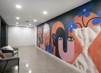 How Curators Bring Artistic Value to Commercial Design Projects An apartment building hallway featuring a mural with graphic shapes and whimsical design with bold, bright colors.