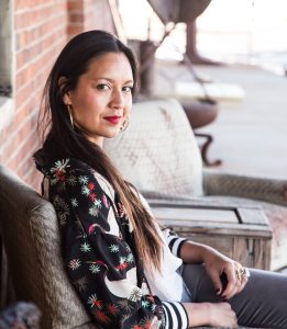 Photo of Tricia Heuring, curator and arts organizer seated at Northrup King Building