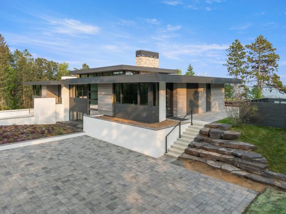 the home is immersed in nature, which is underscored by its use of organic materials. A sloped garden allows more natural light to flow into the lower level, and surrounding plants and trees honor the home&rsquo;s location.