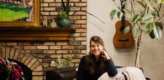 Lidia Valdivia sits in her newly remodeled living room, where raised the previously sunken space and added terracotta floors, and skylights and wood beams to the ceiling, creating an open, inviting atmosphere. Neutral Roman Clay walls allow artwork—some from her travels and home in Nicaragua, some created by her partner—to shine.