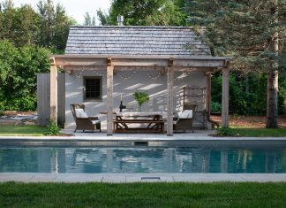 This charming backyard features a serene pool, hot tub, casual dining space, and an accessory building for storing equipment and supplies.