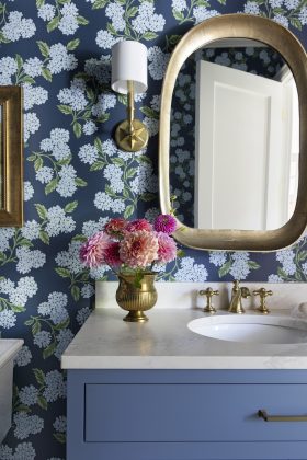 Varying shades of blue subtly tie the interiors back to the lake, while splashes of patterned wallpaper add visual interest in smaller spaces like the powder room.